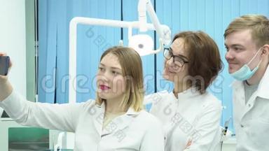 年轻医生做自拍。 媒体。 一组有吸引力的牙医在休息时根据牙科设备的背景进行<strong>自我介绍</strong>